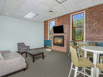 a living room with a fireplace and a table and chairs at Bigelow Commons, Connecticut